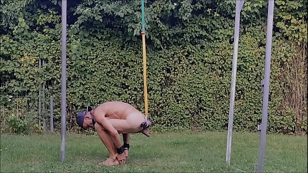 naked pathetic slave exposed outdoor, handcuffed, testicles stretched in humbler, BDSM CBT
